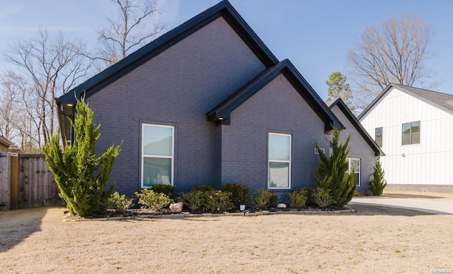 view of home's exterior with brick siding and fence