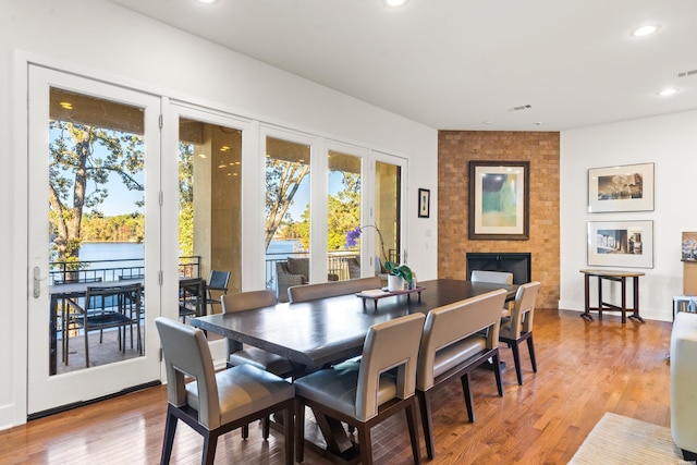 dining room with recessed lighting, visible vents, a fireplace, and wood finished floors