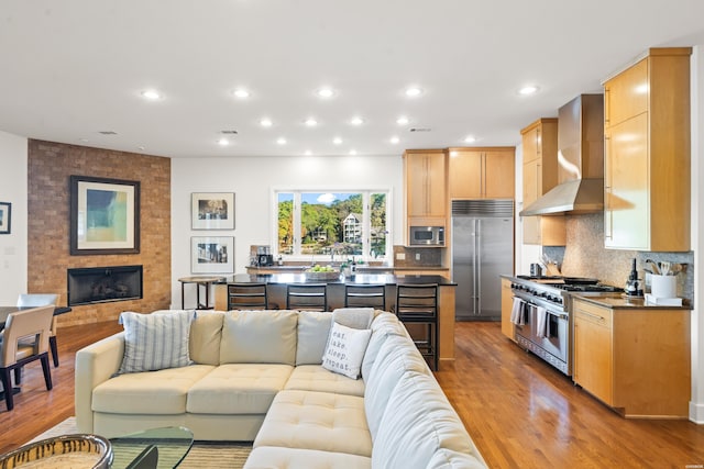 living room with light wood finished floors, a fireplace, visible vents, and recessed lighting