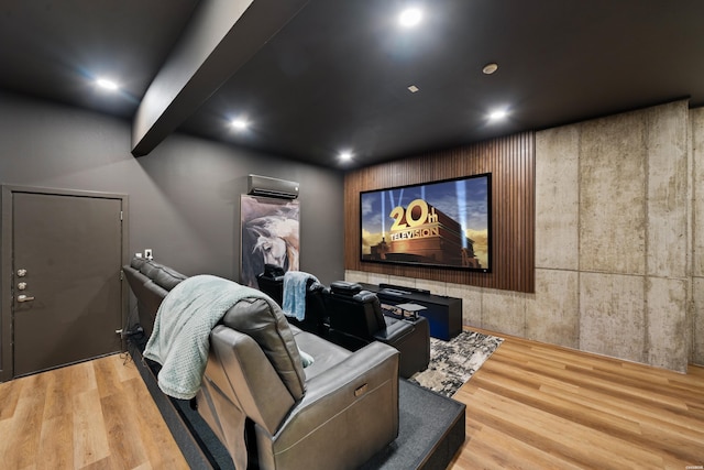 cinema room with an AC wall unit, light wood finished floors, and recessed lighting