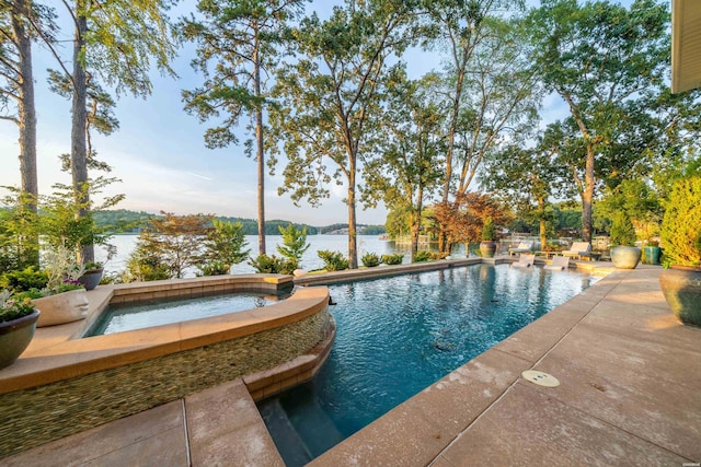 view of pool featuring a patio area, a water view, and a pool with connected hot tub