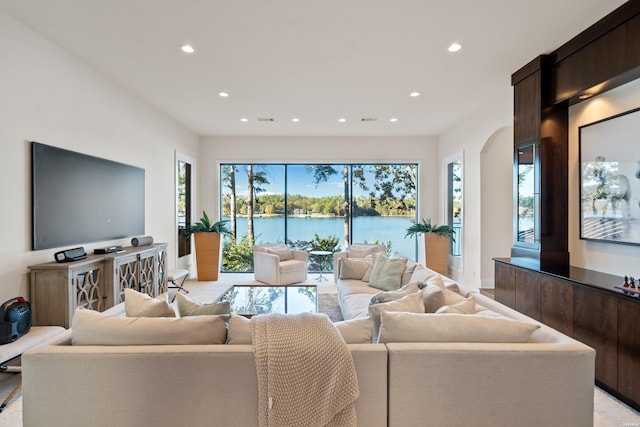 living room with arched walkways, visible vents, and recessed lighting