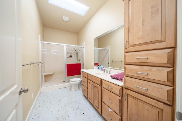 full bath featuring a skylight, toilet, a shower stall, vanity, and baseboards