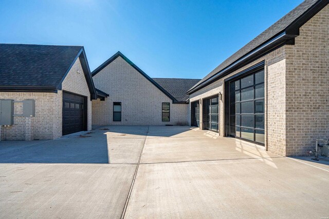 exterior space featuring a garage and brick siding