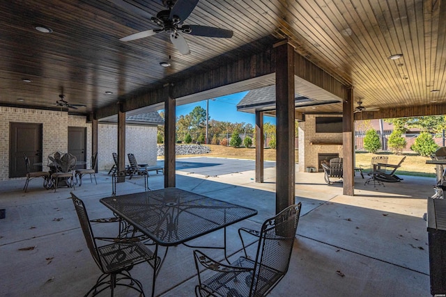 view of patio / terrace featuring ceiling fan, a fireplace, and outdoor dining space