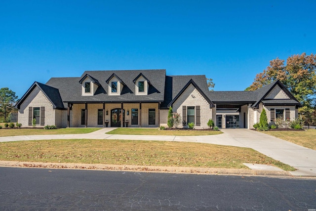 view of front of home with driveway, brick siding, and a front yard