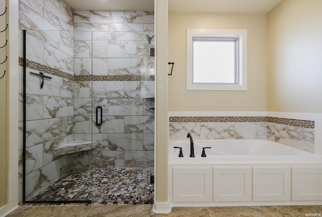 bathroom featuring a shower stall and a bath