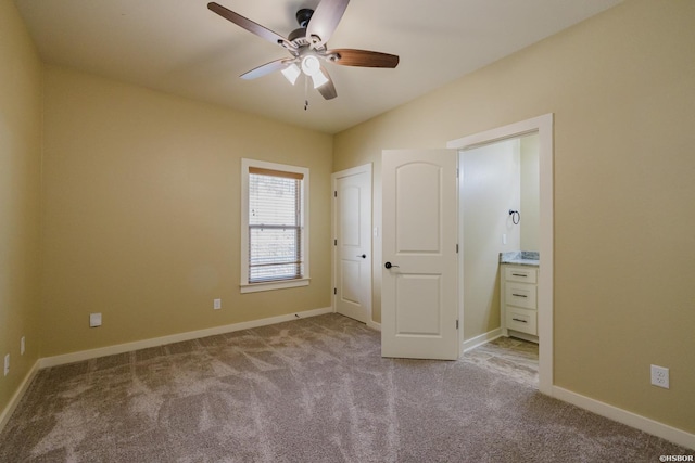 unfurnished bedroom with baseboards, ensuite bathroom, a ceiling fan, and light colored carpet