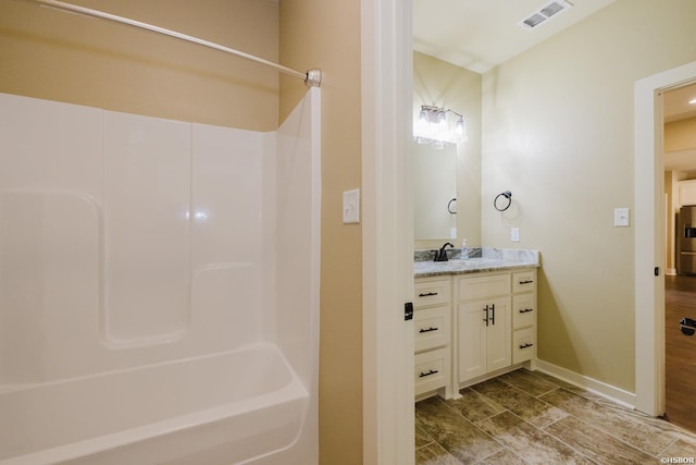 bathroom with bathing tub / shower combination, visible vents, vanity, wood finished floors, and baseboards