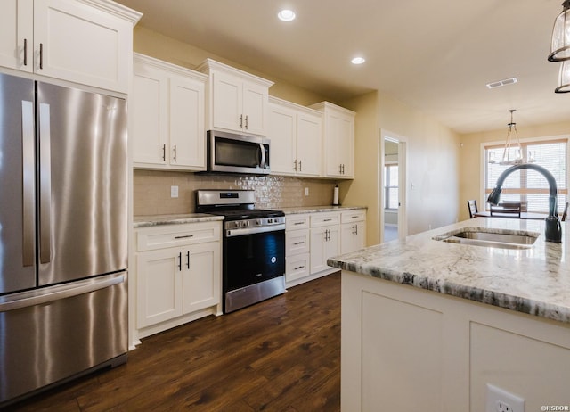 kitchen featuring a sink, visible vents, white cabinetry, appliances with stainless steel finishes, and decorative backsplash