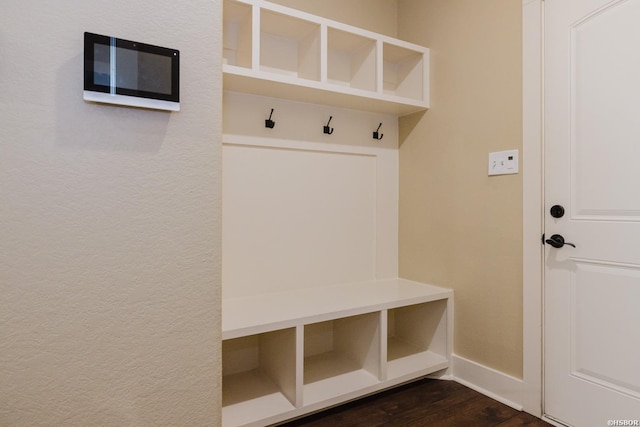 mudroom with dark wood-style floors and baseboards