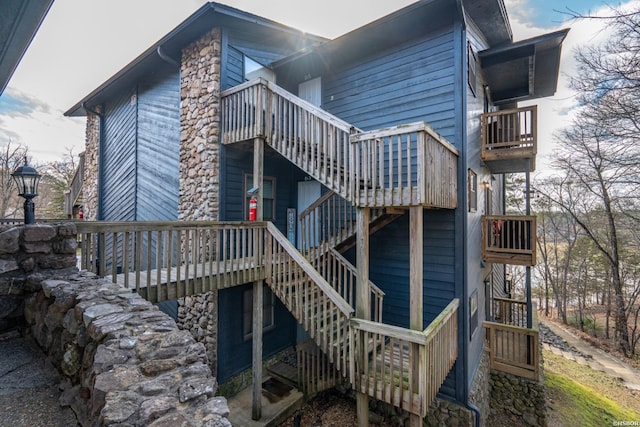 rear view of property featuring stairs and a balcony