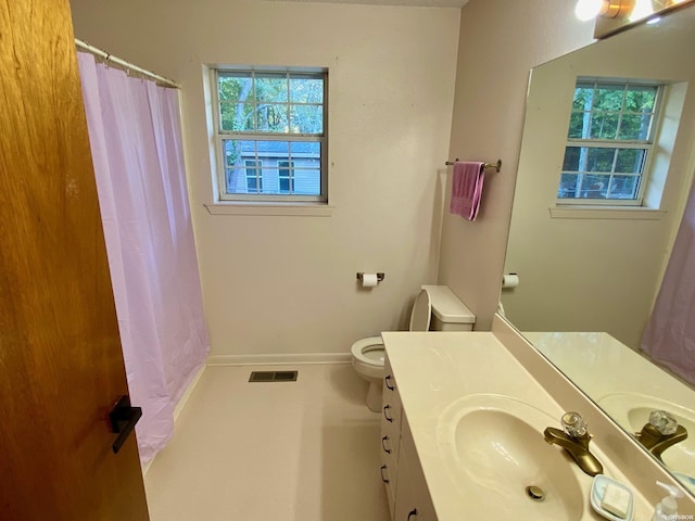 bathroom featuring a wealth of natural light, vanity, visible vents, and baseboards