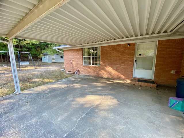 view of patio with a carport, an outdoor structure, and a shed