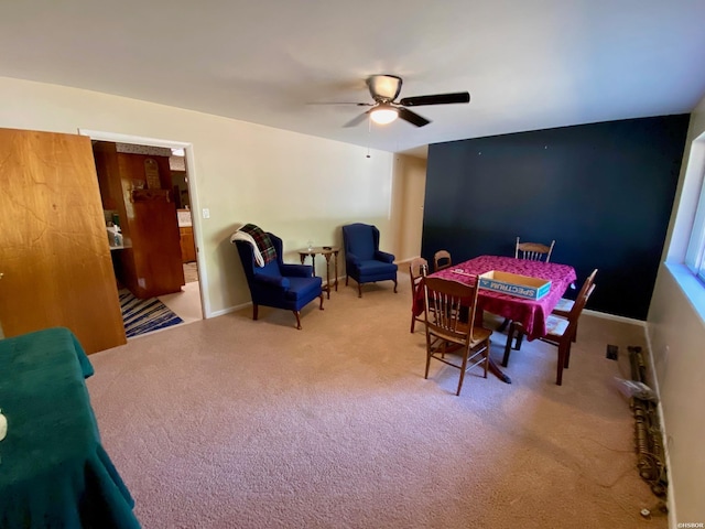 carpeted dining space with ceiling fan and baseboards