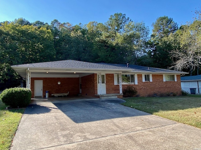 ranch-style home with brick siding, concrete driveway, a front yard, crawl space, and an attached carport