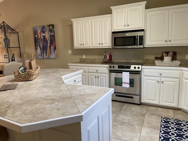 141 Central Ter Unit D, Hot Springs, AR 71913 - kitchen featuring tile countertops, stainless steel appliances, light tile patterned flooring, and white cabinets