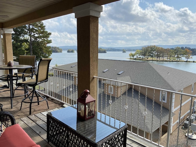 balcony featuring outdoor dining space and a water view