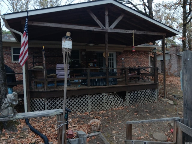 back of property featuring a wooden deck and brick siding