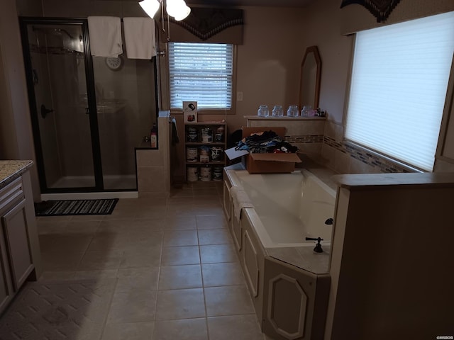 full bath with tile patterned flooring, a bath, and vanity