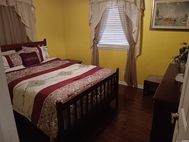 bedroom with baseboards and dark wood-style flooring