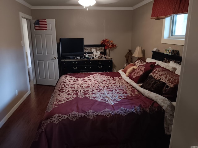 bedroom with dark wood-style floors, baseboards, and crown molding