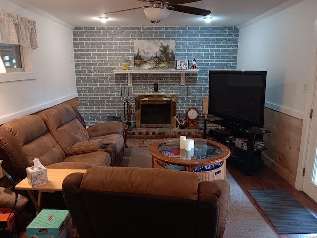 living area featuring a ceiling fan and a brick fireplace