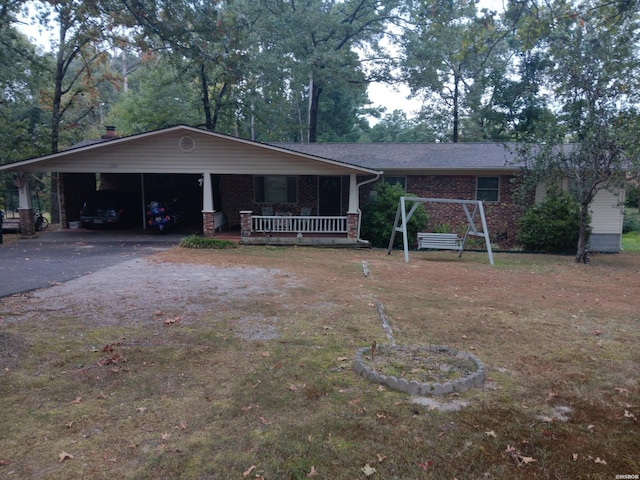 ranch-style house with a porch, aphalt driveway, and brick siding