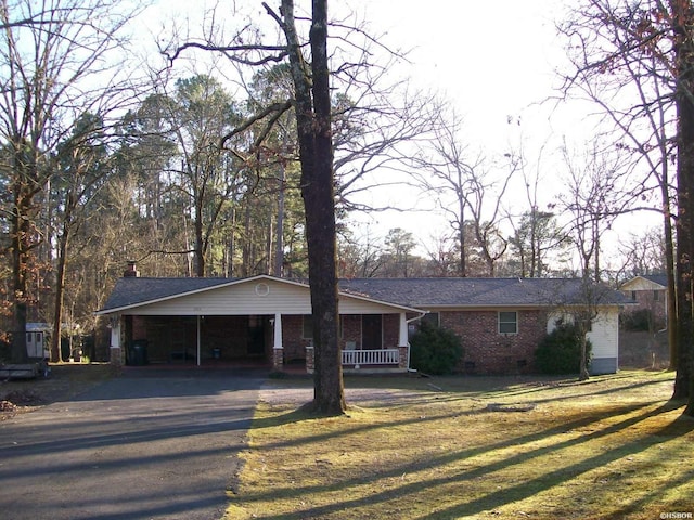 single story home with driveway, crawl space, a front lawn, a porch, and brick siding