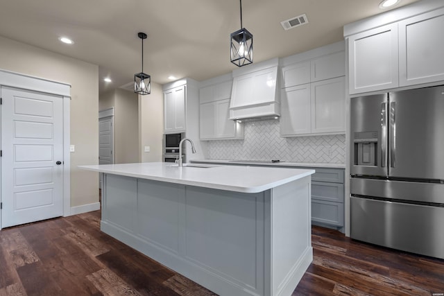 kitchen featuring light countertops, hanging light fixtures, visible vents, a sink, and stainless steel fridge with ice dispenser