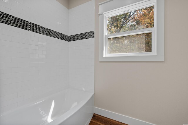 bathroom featuring shower / bathtub combination, wood finished floors, and baseboards