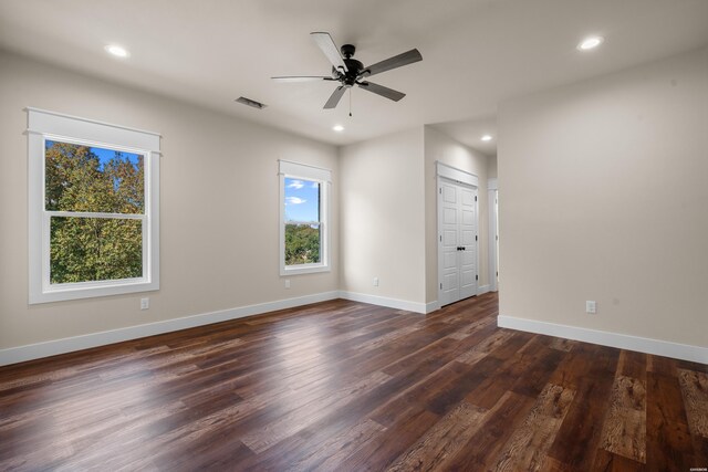 spare room featuring dark wood-type flooring, recessed lighting, visible vents, and baseboards