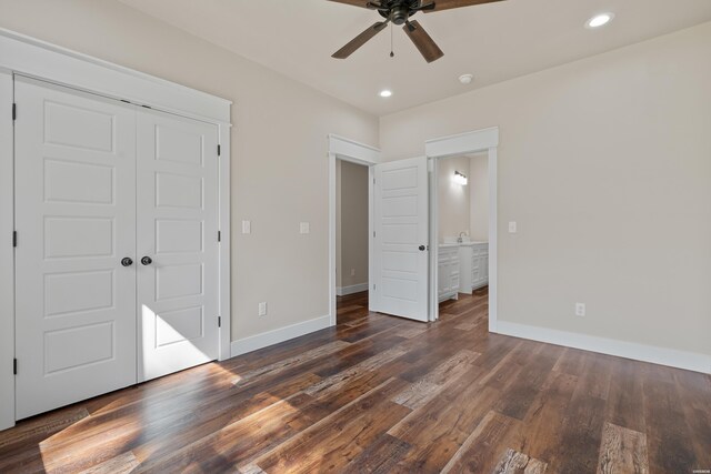 unfurnished bedroom featuring baseboards and dark wood-type flooring