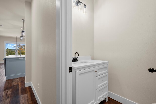 bathroom with wood finished floors, vanity, and baseboards