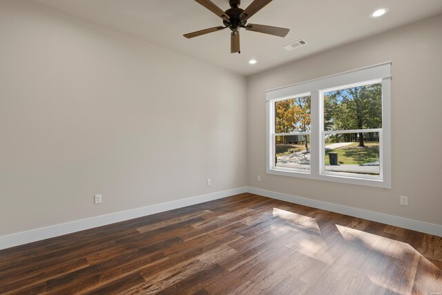 unfurnished room with dark wood-style floors, baseboards, visible vents, and recessed lighting