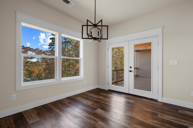 unfurnished dining area with dark wood-type flooring, french doors, visible vents, and baseboards