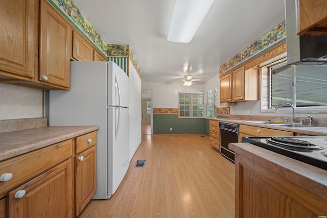 kitchen featuring light wood-style flooring, a sink, visible vents, light countertops, and freestanding refrigerator