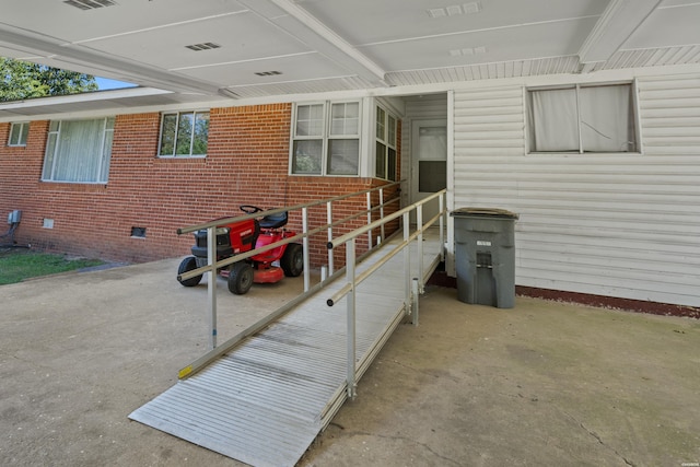 property entrance featuring visible vents and brick siding