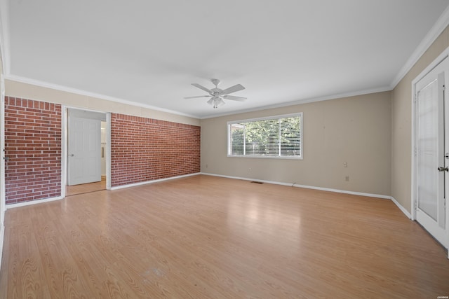 unfurnished room featuring light wood finished floors, ornamental molding, a ceiling fan, brick wall, and baseboards