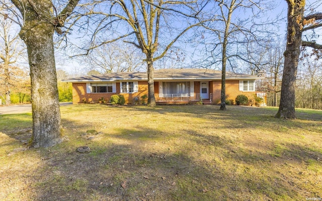 ranch-style house featuring a front yard and brick siding