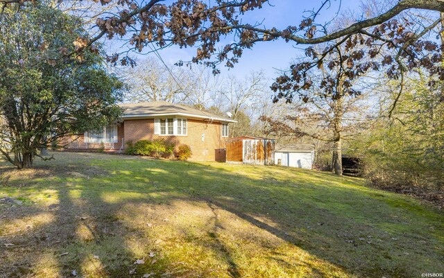 view of side of property with brick siding and a lawn