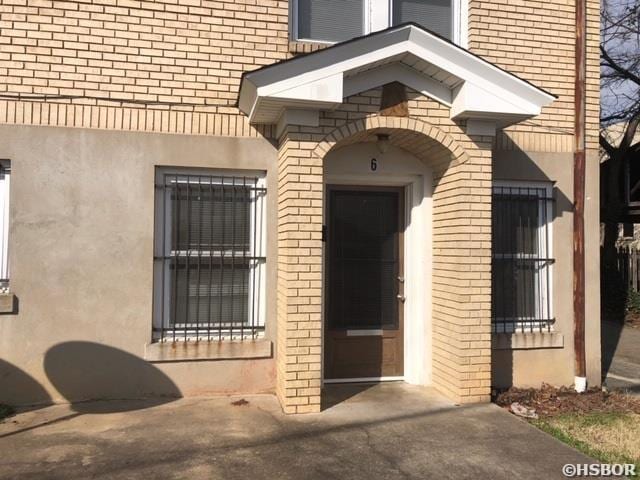 doorway to property featuring stucco siding