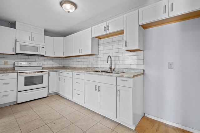 kitchen featuring white cabinetry, white appliances, tasteful backsplash, and a sink