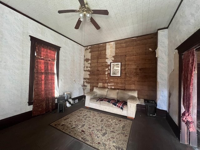 unfurnished living room featuring ornamental molding and a ceiling fan