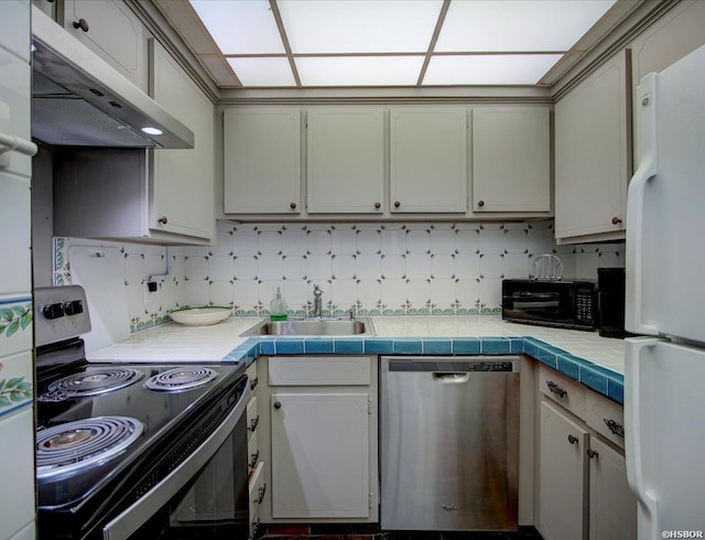 kitchen with stainless steel dishwasher, electric stove, black microwave, under cabinet range hood, and freestanding refrigerator