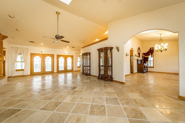 living room with visible vents, baseboards, ceiling fan with notable chandelier, arched walkways, and high vaulted ceiling