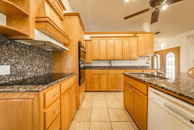 kitchen with dark stone counters, decorative backsplash, white dishwasher, black electric cooktop, and a sink