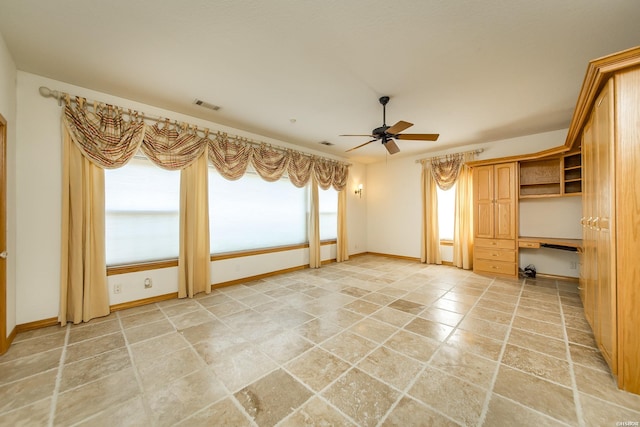 spare room with baseboards, visible vents, and ceiling fan