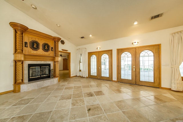 entryway with lofted ceiling, french doors, visible vents, and a premium fireplace