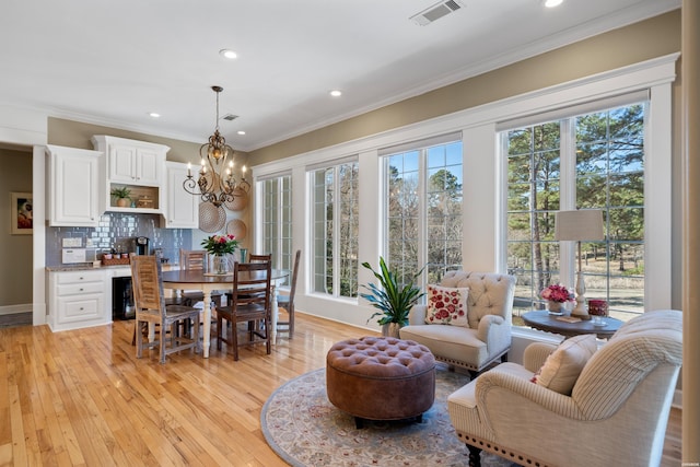 dining room with light wood-style flooring, recessed lighting, visible vents, ornamental molding, and an inviting chandelier